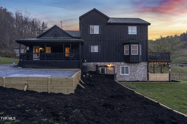 136 Beecher Holtsclaw Rd, Roan Mountain, TN 37687 - rear view of property featuring metal roof, covered porch, a lawn, stone siding, and a standing seam roof