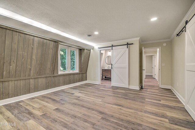 505 Red Oak Ln, Kingsport, TN 37663 - unfurnished bedroom with a barn door, crown molding, wood finished floors, recessed lighting, and ensuite bathroom