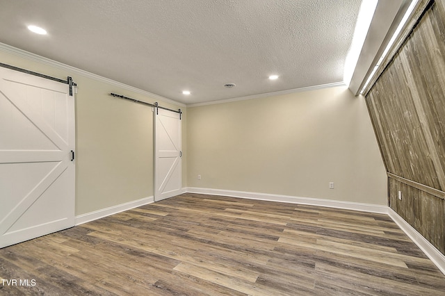 505 Red Oak Ln, Kingsport, TN 37663 - unfurnished bedroom with a barn door, ornamental molding, recessed lighting, wood finished floors, and a textured ceiling