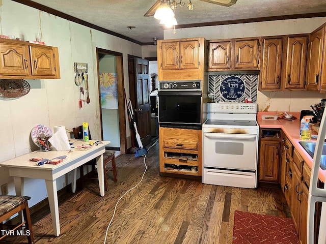 12615 Star Branch Rd, Coeburn, VA 24230 - kitchen with electric stove, black oven, ornamental molding, dark wood-type flooring, and brown cabinets