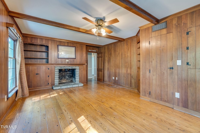 421 High Ridge Rd, Kingsport, TN 37660 - unfurnished living room featuring wood walls, healthy amount of natural light, a fireplace with raised hearth, a ceiling fan, and hardwood / wood-style flooring