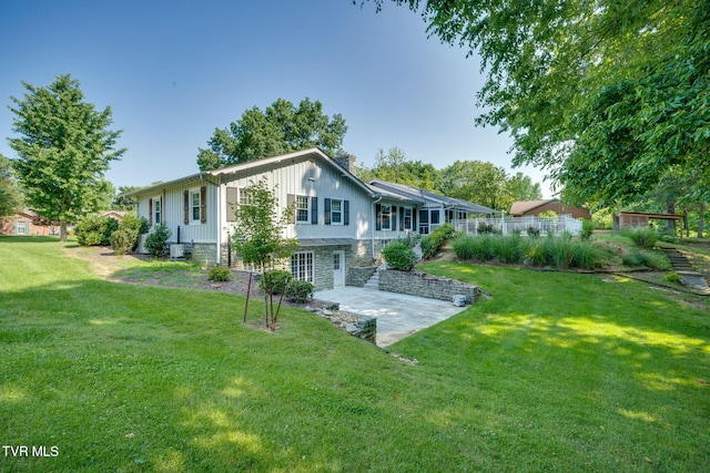 421 High Ridge Rd, Kingsport, TN 37660 - rear view of house with board and batten siding, a patio area, a lawn, and stone siding