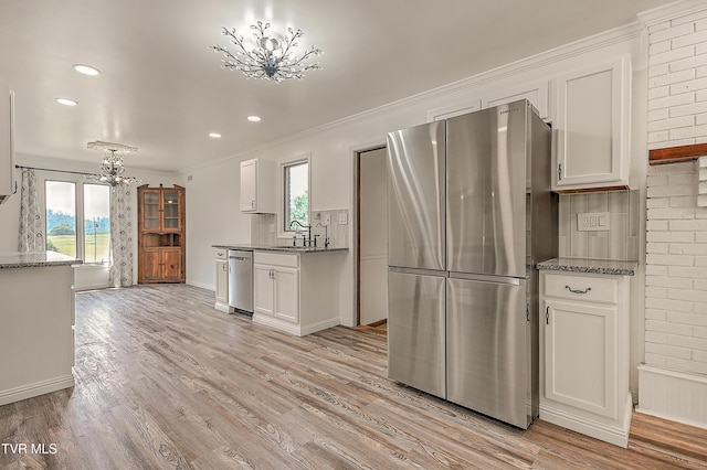 14191 King Mill Pike, Bristol, VA 24202 - kitchen with stainless steel appliances, a chandelier, decorative backsplash, white cabinets, and light wood-type flooring