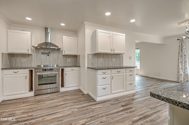 14191 King Mill Pike, Bristol, VA 24202 - kitchen with wall chimney range hood, stainless steel range with electric stovetop, light wood finished floors, white cabinets, and crown molding