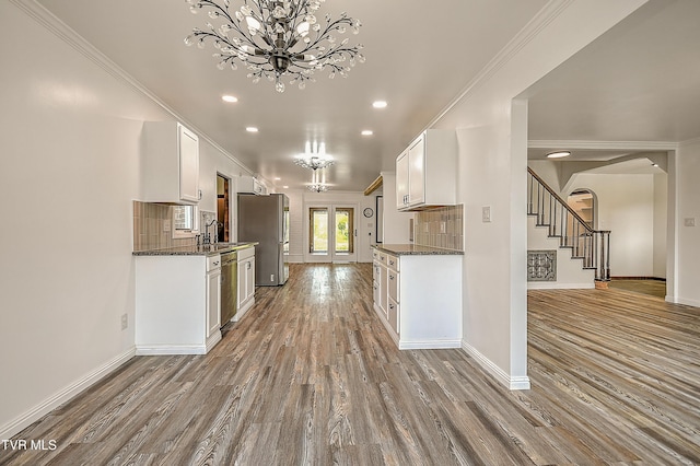 14191 King Mill Pike, Bristol, VA 24202 - kitchen featuring stainless steel appliances, wood finished floors, a chandelier, baseboards, and crown molding