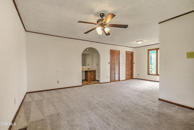14191 King Mill Pike, Bristol, VA 24202 - carpeted empty room with a textured ceiling, a ceiling fan, arched walkways, and baseboards