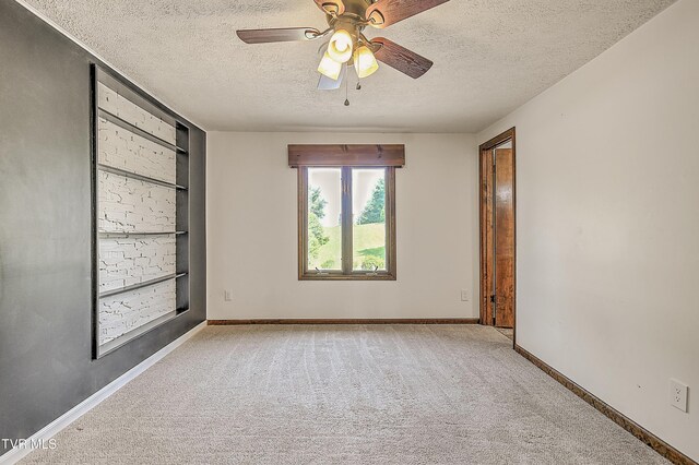 14191 King Mill Pike, Bristol, VA 24202 - empty room featuring carpet flooring, a textured ceiling, built in shelves, a ceiling fan, and baseboards