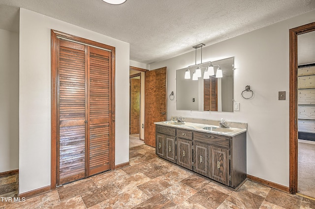 14191 King Mill Pike, Bristol, VA 24202 - bathroom with double vanity, baseboards, a closet, stone finish floors, and a textured ceiling