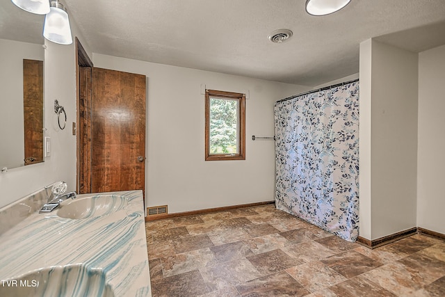 14191 King Mill Pike, Bristol, VA 24202 - bathroom featuring baseboards, vanity, stone finish flooring, curtained shower, and a textured ceiling