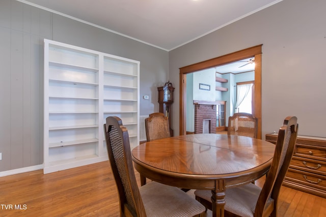 915 Lawrence Ave, Bristol, VA 24201 - dining room with light wood-style floors, a fireplace, crown molding, baseboards, and built in shelves
