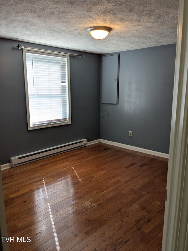 1319 5th St, Bristol, TN 37620 - unfurnished room featuring a baseboard heating unit, a textured ceiling, wood finished floors, and baseboards