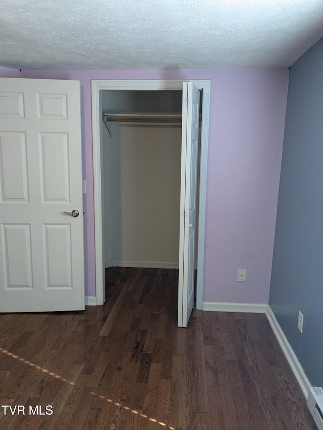 1319 5th St, Bristol, TN 37620 - unfurnished bedroom featuring a closet, a textured ceiling, wood finished floors, a baseboard radiator, and baseboards