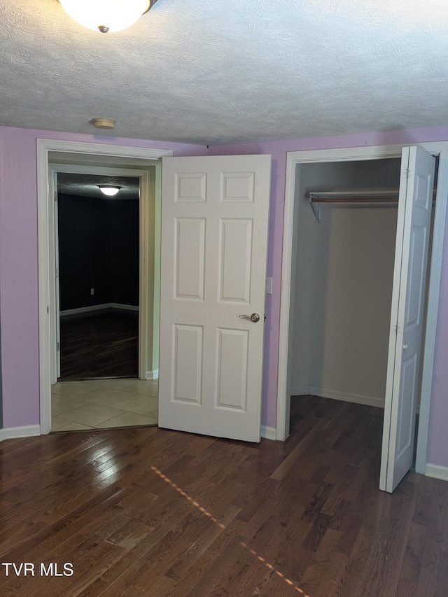 1319 5th St, Bristol, TN 37620 - unfurnished bedroom with a closet, wood finished floors, a textured ceiling, and baseboards