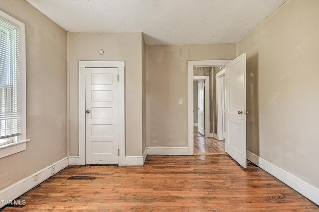 1725 Highland St, Kingsport, TN 37664 - spare room with wood finished floors, plenty of natural light, a textured ceiling, and baseboards