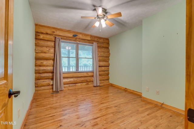 366 Judge Ben Allen Rd, Elizabethton, TN 37643 - unfurnished room featuring log walls, light wood-style floors, a ceiling fan, a textured ceiling, and baseboards