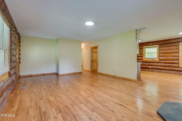 366 Judge Ben Allen Rd, Elizabethton, TN 37643 - unfurnished living room with rustic walls, light wood-type flooring, and baseboards