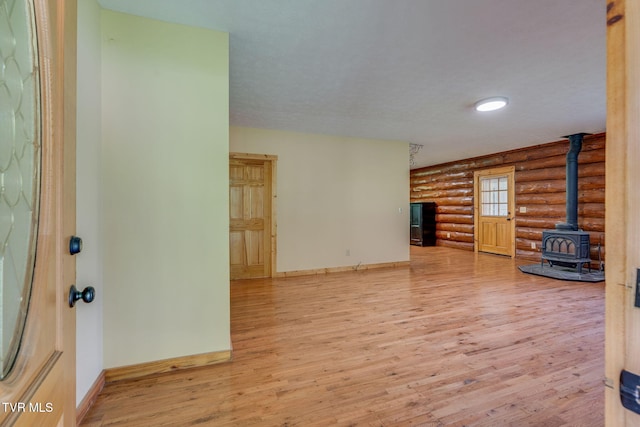 366 Judge Ben Allen Rd, Elizabethton, TN 37643 - unfurnished living room with rustic walls, a wood stove, baseboards, and wood finished floors