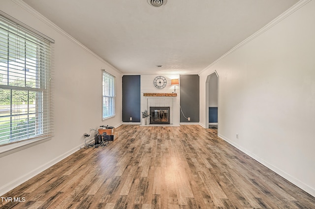 112 Hillview Rd, Kingsport, TN 37664 - unfurnished living room with crown molding, healthy amount of natural light, wood finished floors, a tiled fireplace, and arched walkways