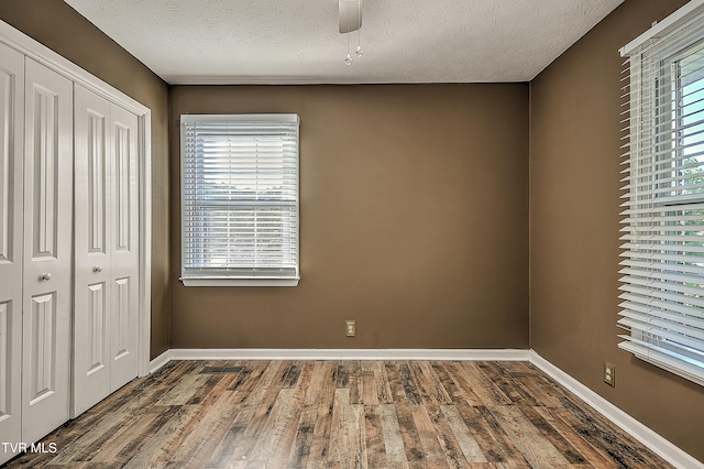 112 Hillview Rd, Kingsport, TN 37664 - unfurnished bedroom featuring wood finished floors, a closet, a textured ceiling, and a ceiling fan