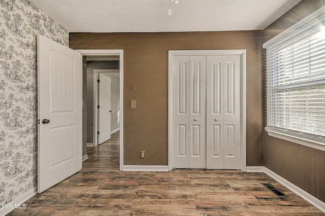 112 Hillview Rd, Kingsport, TN 37664 - unfurnished bedroom with wallpapered walls, wood finished floors, a closet, and multiple windows