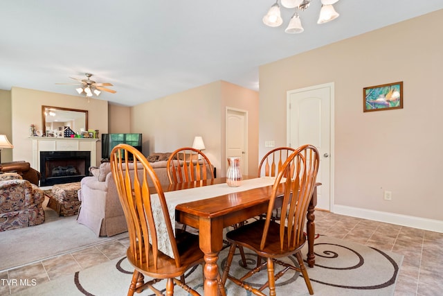 2898 Watauga Rd, Johnson City, TN 37601 - dining room featuring ceiling fan, a fireplace, a chandelier, light tile patterned floors, and baseboards