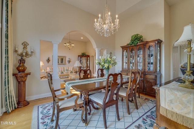 100 Pointe Dr, Piney Flats, TN 37686 - dining area with a chandelier, a towering ceiling, arched walkways, light wood-style flooring, and ornate columns