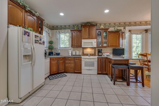 100 Pointe Dr, Piney Flats, TN 37686 - kitchen with white appliances, a sink, brown cabinetry, a peninsula, and recessed lighting