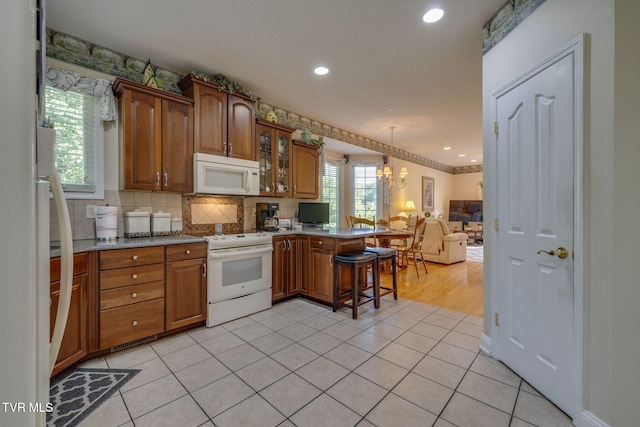 100 Pointe Dr, Piney Flats, TN 37686 - kitchen featuring white appliances, a peninsula, open floor plan, a kitchen bar, and glass insert cabinets