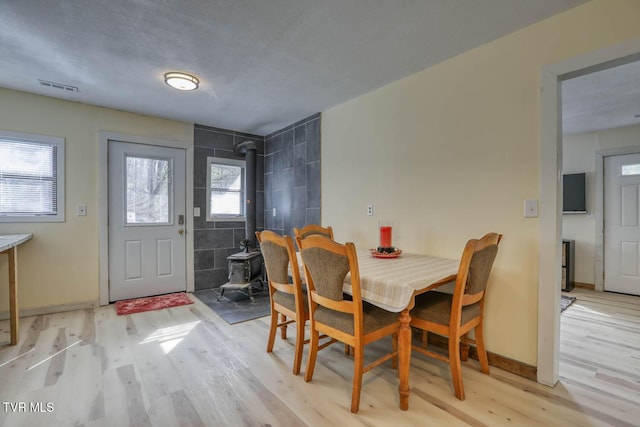 7300 Snake Hollow Rd, Sneedville, TN 37869 - dining area featuring a wood stove, light wood finished floors, and baseboards