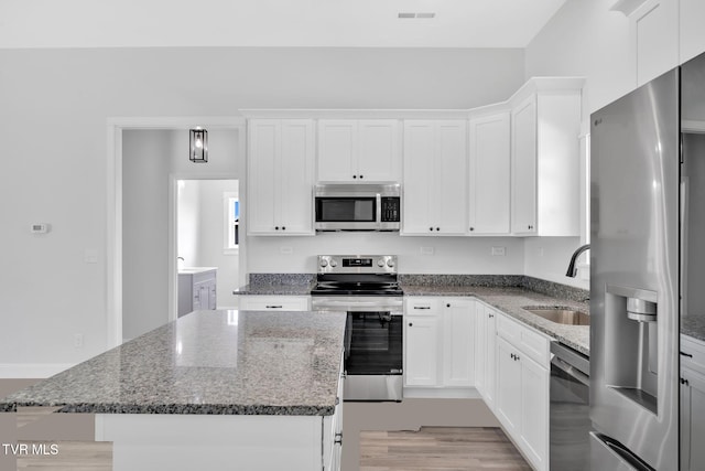 1930 Erwin Hwy, Greeneville, TN 37745 - kitchen featuring stainless steel appliances, a kitchen island, white cabinets, and dark stone counters