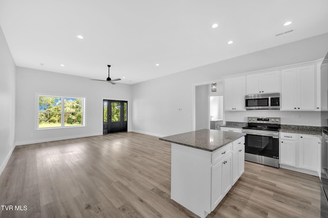 1930 Erwin Hwy, Greeneville, TN 37745 - kitchen featuring stainless steel appliances, a kitchen island, a ceiling fan, dark stone counters, and light wood finished floors