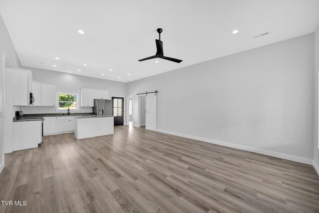 1930 Erwin Hwy, Greeneville, TN 37745 - unfurnished living room featuring a barn door, light wood finished floors, a ceiling fan, and recessed lighting