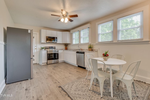 645 Suffolk Ave, Bristol, VA 24201 - kitchen with appliances with stainless steel finishes, white cabinetry, light wood finished floors, and a ceiling fan