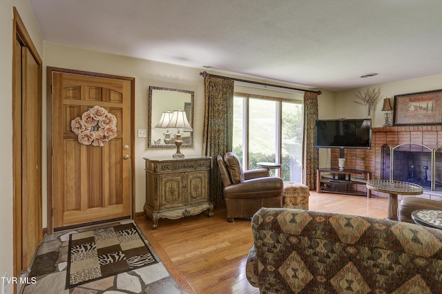 296 Redstone Dr, Bluff City, TN 37618 - living room featuring light wood-type flooring and a brick fireplace
