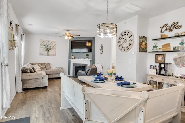 1058 Raccoon Ln, Piney Flats, TN 37686 - dining area featuring ceiling fan, a fireplace, and wood finished floors