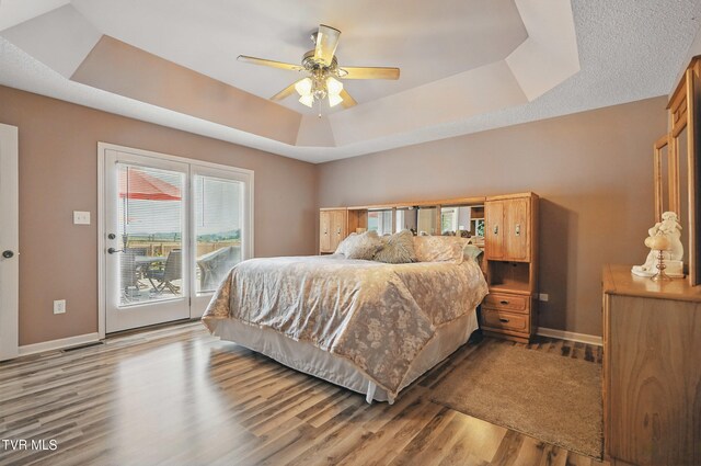 17308 Crabtree Ct, Bristol, VA 24202 - bedroom featuring access to outside, a tray ceiling, wood finished floors, baseboards, and a ceiling fan