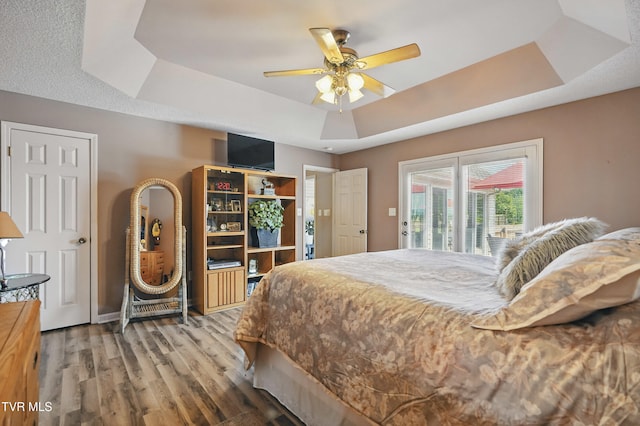 17308 Crabtree Ct, Bristol, VA 24202 - bedroom with a tray ceiling, access to outside, wood finished floors, and ceiling fan