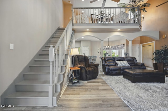 17308 Crabtree Ct, Bristol, VA 24202 - living room with arched walkways, a chandelier, a towering ceiling, stairs, and wood finished floors