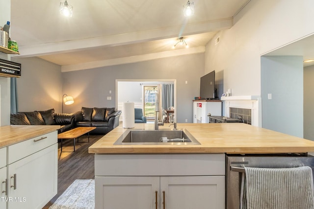 172 Dakota Rd, Bristol, VA 24201 - kitchen with open floor plan, wood counters, stainless steel dishwasher, dark wood-style flooring, and white cabinetry