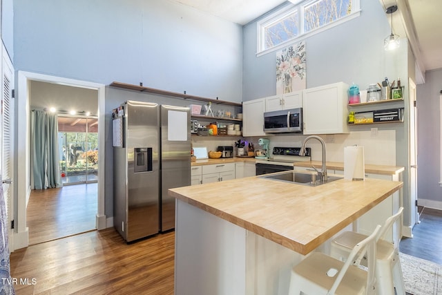 172 Dakota Rd, Bristol, VA 24201 - kitchen with stainless steel appliances, open shelves, wooden counters, a towering ceiling, and wood finished floors