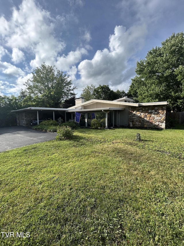 172 Dakota Rd, Bristol, VA 24201 - view of front of home featuring asphalt driveway, a front lawn, a carport, a chimney, and stone siding