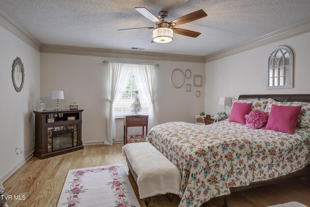 1905 Knob Creek Rd Unit 11, Johnson City, TN 37604 - bedroom featuring ornamental molding, wood finished floors, a textured ceiling, ceiling fan, and a premium fireplace