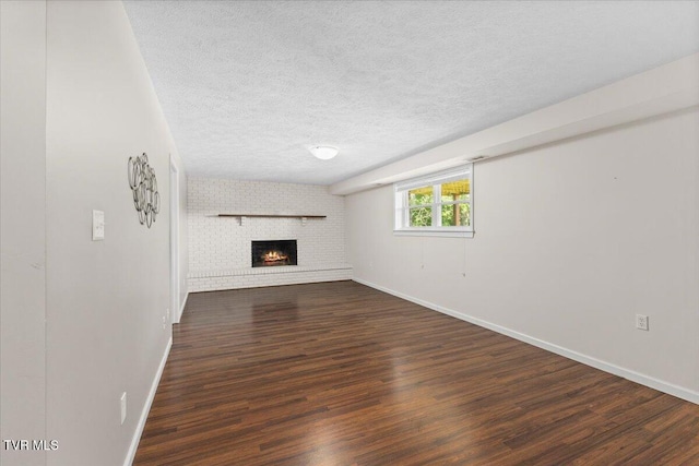 152 Ezee St, Elizabethton, TN 37643 - unfurnished living room featuring dark wood-style flooring, a fireplace, and a textured ceiling