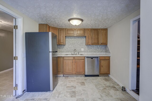 3912 Memorial Blvd, Kingsport, TN 37664 - kitchen with freestanding refrigerator, stainless steel dishwasher, light countertops, brown cabinetry, and decorative backsplash