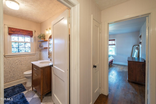 1024 Sharondale Ave, Kingsport, TN 37660 - half bathroom featuring vanity, toilet, a textured ceiling, wood finished floors, and baseboards