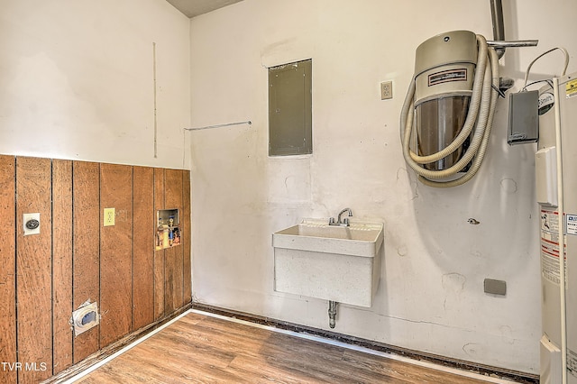 646 Meadow View Rd, Bristol, TN 37620 - laundry area with electric panel, wood finished floors, a sink, and water heater