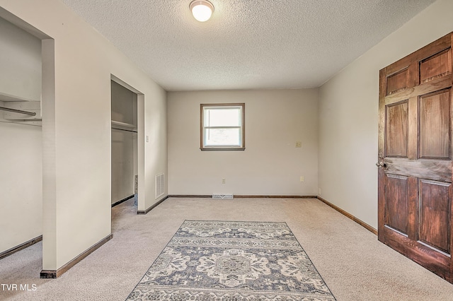 646 Meadow View Rd, Bristol, TN 37620 - unfurnished bedroom with a textured ceiling, light colored carpet, baseboards, and two closets