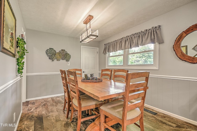 404 Stuffle St, Kingsport, TN 37660 - dining area with a wainscoted wall, a textured ceiling, and a decorative wall