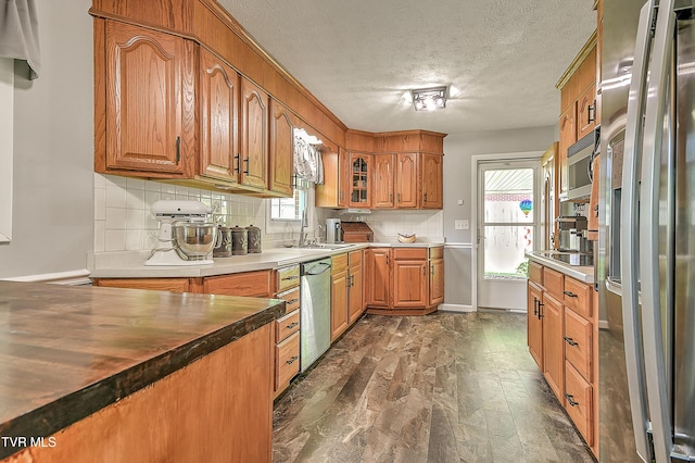 404 Stuffle St, Kingsport, TN 37660 - kitchen with appliances with stainless steel finishes, brown cabinets, a textured ceiling, healthy amount of natural light, and tasteful backsplash