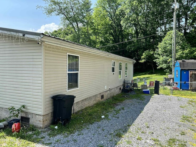 692 NE Hamner Ave, Norton, VA 24273 - view of property exterior featuring crawl space, a gate, a storage shed, and gravel driveway